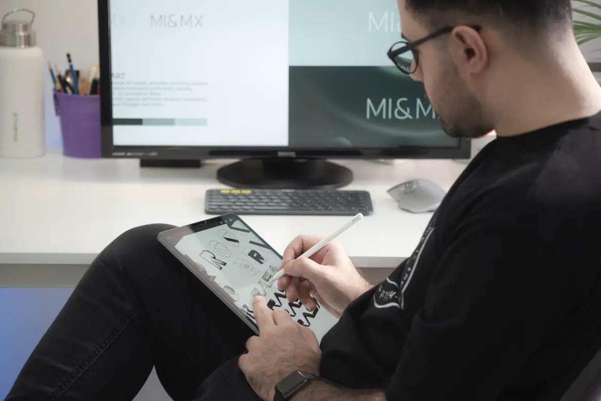 Photo by Milad Fakurian man in black long sleeve shirt sitting beside black flat screen computer monitor