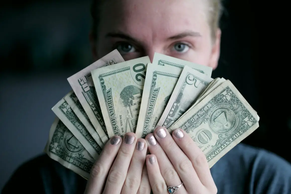 Photo by Alexander Grey person holding fan of U.S. dollars banknote
